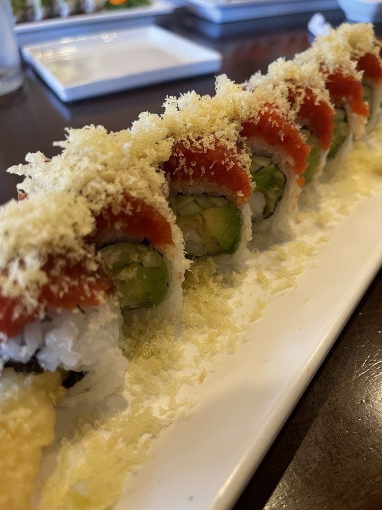 A crunchy roll close-up topped with tuna and tempura crumbs
