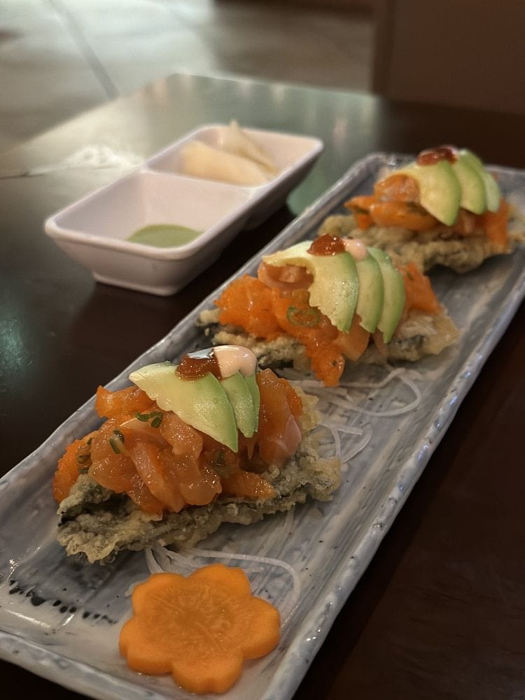 Crispy salmon and avocado bites with a flower-cut carrot, plated long