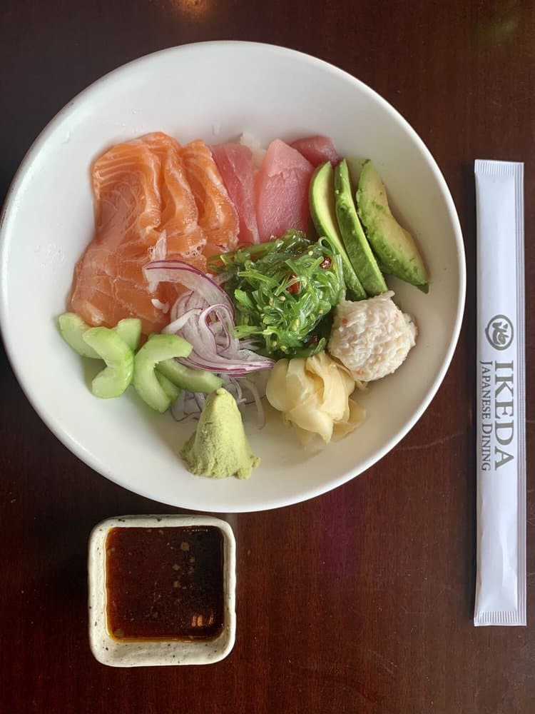 A poke bowl with salmon, tuna, seaweed salad, avocado and crab
