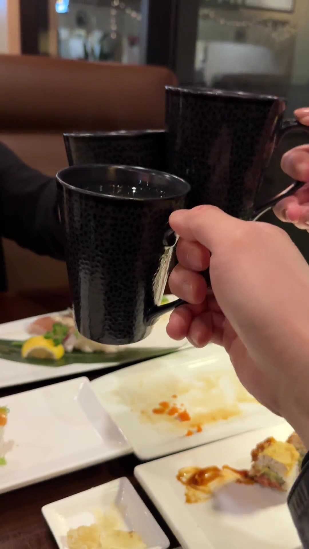 Friends cheers with ceramic mugs at Ikeda